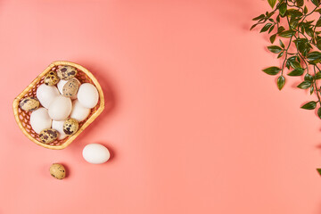 Eggs for Easter in a basket with spring leaves pink background