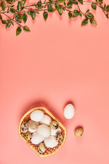 Eggs for Easter in a basket with spring leaves pink background