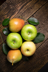 Apples and pears on a wooden table.Fresh fruits are picturesquely arranged on a wooden background.