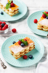 Classic french dessert millefeuille with vanilla cream and fresh berries.