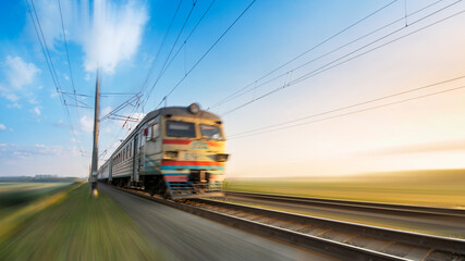 Fototapeta premium A passenger train on the railway is moving at high speed