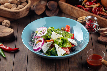 Plate of greek salad with fresh vegetables on wooden decorated background