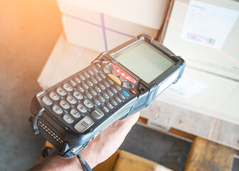 Close-up Worker Holding Bar Code Scanner is Scanning on Package Boxes. Computer Work Tools for...