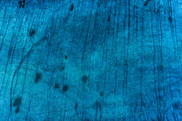 Water streaks and spots of dried water on a blue surface.