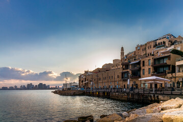 Fototapeta premium View of street facing the old port of Jaffa in Israel with a colorful sunrise on Tel Aviv