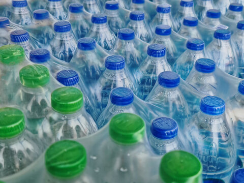 High Angle View of Packs of Bottled Drinking Water with Blue and Green Caps