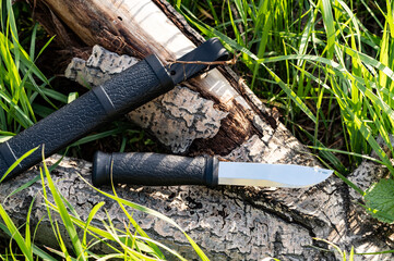 Knife with a fixed blade on the stump. Knife and sheath. Outdoor hunting knife. Top view.