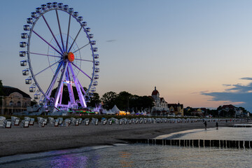 Promenade of Kuehlungsborn with a ferris wheel in the twilight , Germany