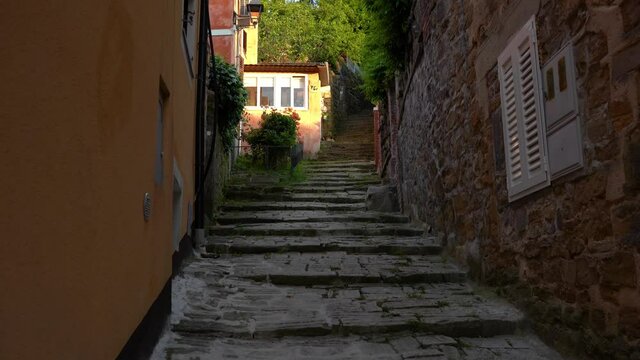 Old ancient stairs of stone in small medieval town Piran, Sovenia. Beautiful historic narrow street in Europe. Mediterranean architecture. Tilt up, wide angle