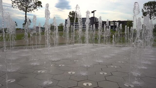 Koper, Slovenia: water fountain in public park on a sunny day. Beautiful public park near Adriatic Sea. Slow motion, right tracking