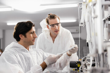 Obraz premium Technician or engineer working checking mask production machine at clean factory or laboratory