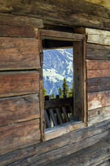 Blick durch das Fenster eines alten Bauernhauses in den österreichischen Alpen