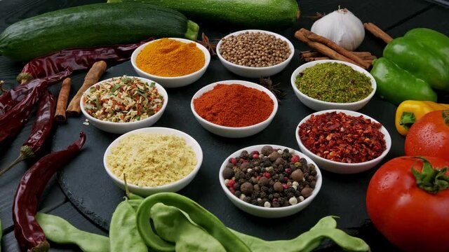 Colorful herbs and spices for cooking. Indian spices. On a black background. Top view