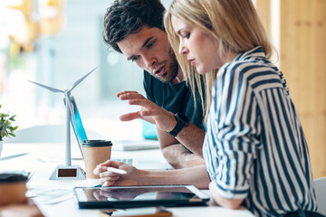Successful business team working together with digital tablet in coworking place.