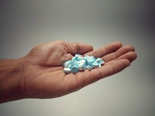 Hands have a lot of pills. Vintage style vignette white background, giving the idea of suicide, despair, wanting to die, short thinking.