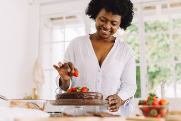 African female preparing delicious cake at home