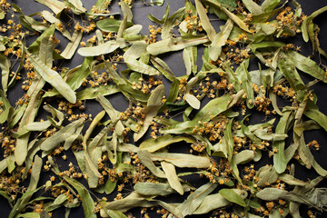 Natural pattern of dry linden flowers for tea, on black background.