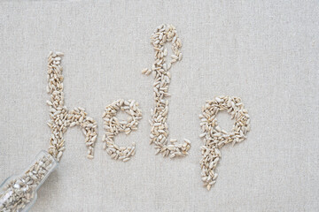On a gray background, there are seeds in the form of letters and the word "help"