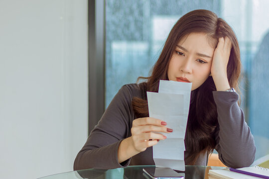 unhappy woman sit on chair in living room,look at troble thing on credit pay bill