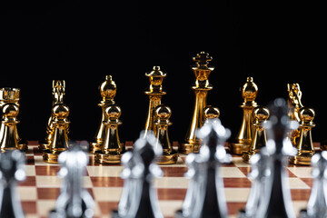Gold and silver chess figures on chessboard