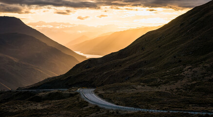 The beautiful road between Queenstown and Wanaka via Crown range. Grassland and beautiful landscape of rocky mountains.