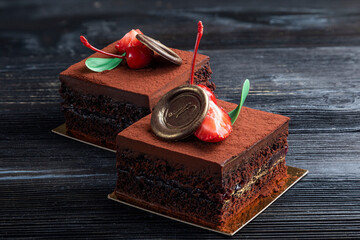 chocolate dessert decorated with a slice of strawberry on a dark background