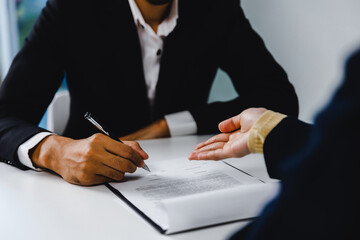 Close up hand of businessman sign contract and female lawyer or judge consult having team meeting with client, Law and Legal services concept.  service good cooperation