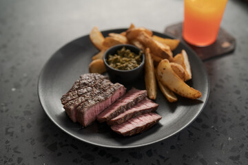 Grilled beef steak with roasted potatoes and pesto sauce