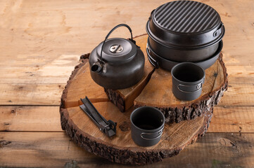 Tourist tableware stumps. Aluminum tableware for tourism. Pots and kettle on stumps. Top view at an...