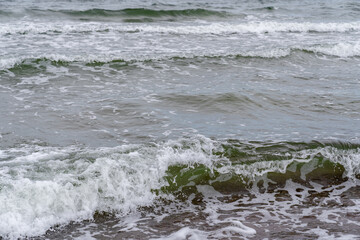 Foaming sea waves flowing to the shore of the Baltic Sea