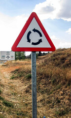 Señal de aviso de rotonda en una carretera.