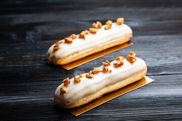 Traditional French dessert. Eclair with white chocolate. Dark background