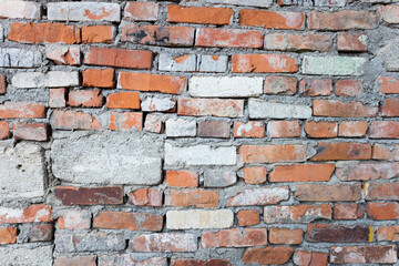 Fototapeta premium The old wall is made of different bricks and blocks. Abstract background image