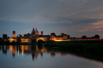 The Mantua (Mantova) skyline at dusk. Beautiful Italian city reflecting on the Mincio river waters.