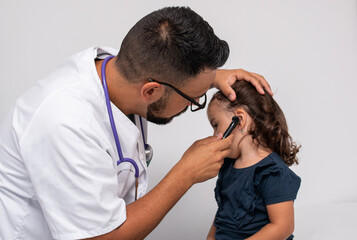 Pediatrician examining the ears of her little patient