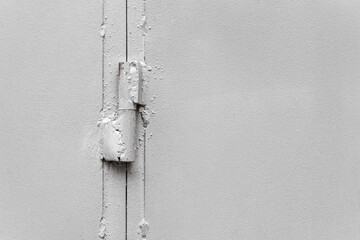 Hinge on painted gray metal gate close-up