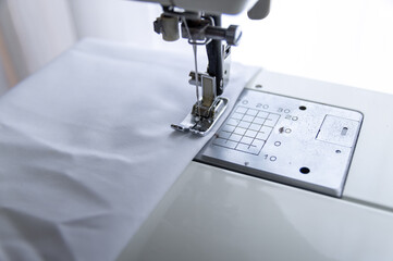 ミシンで白い布を縫う