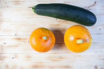 fresh vegetables orange pumpkins and green zucchini on wooden table