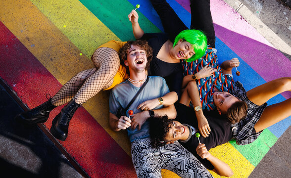 Four young queer people lying down together