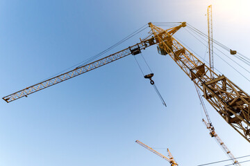 Construction crane. Huge crane against blue sky. Self-erection cranr. Tower crane.