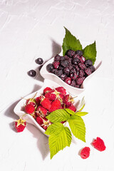 Assorted red and black raspberries in ceramic bowls