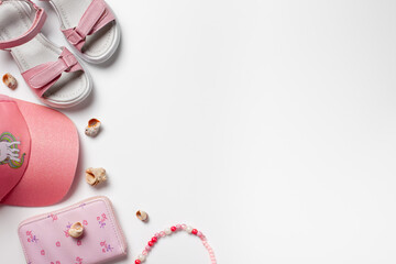 Flat lay with summer accessories. Girl's accessories, pink sandals and cap on the white isolated background with copy space. 