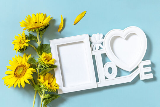 Picture frame, Sunflower photo frame with copy space on pastel blue background.