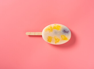 top view fresh milk popsicle mixed with blackberry and blueberry and mango slices and pineapple slices on a pink background