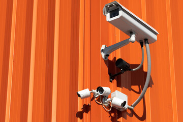 video surveillance cameras installed on the red wall at the entrance to the supermarket. Security and anti-theft systems.