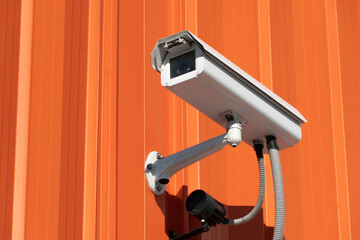 video surveillance cameras installed on the red wall at the entrance to the supermarket. Security...