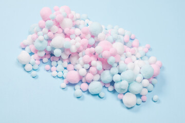 White, pink and blue soft pompons as a background.