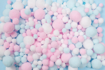 White, pink and blue soft pompons as a background.