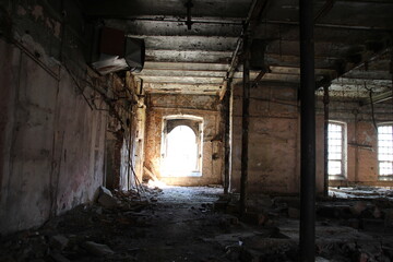 Fototapeta na wymiar old abandoned factory building interior with columns, light in windows