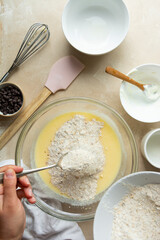 Mixing ingredients for cooking cake or muffins in glass bowl, top view. Step by step recipe.